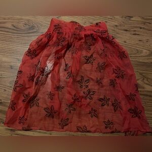 red mesh overlay skirt with a black floral print, possibly a vintage Patra item